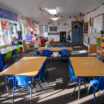 Bright preschool classroom at Little Tykes with child-sized tables, chairs, and learning materials.