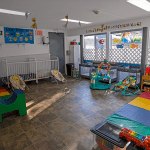 Infant classroom at Little Tykes with cribs, play mats, and age-appropriate learning toys.
