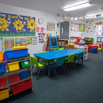 Colorful preschool classroom at Little Tykes with learning centers and child-sized tables and chairs.