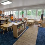 Preschool classroom at Little Tykes in Lodi, NJ, with child-sized tables, learning centers, and large windows.